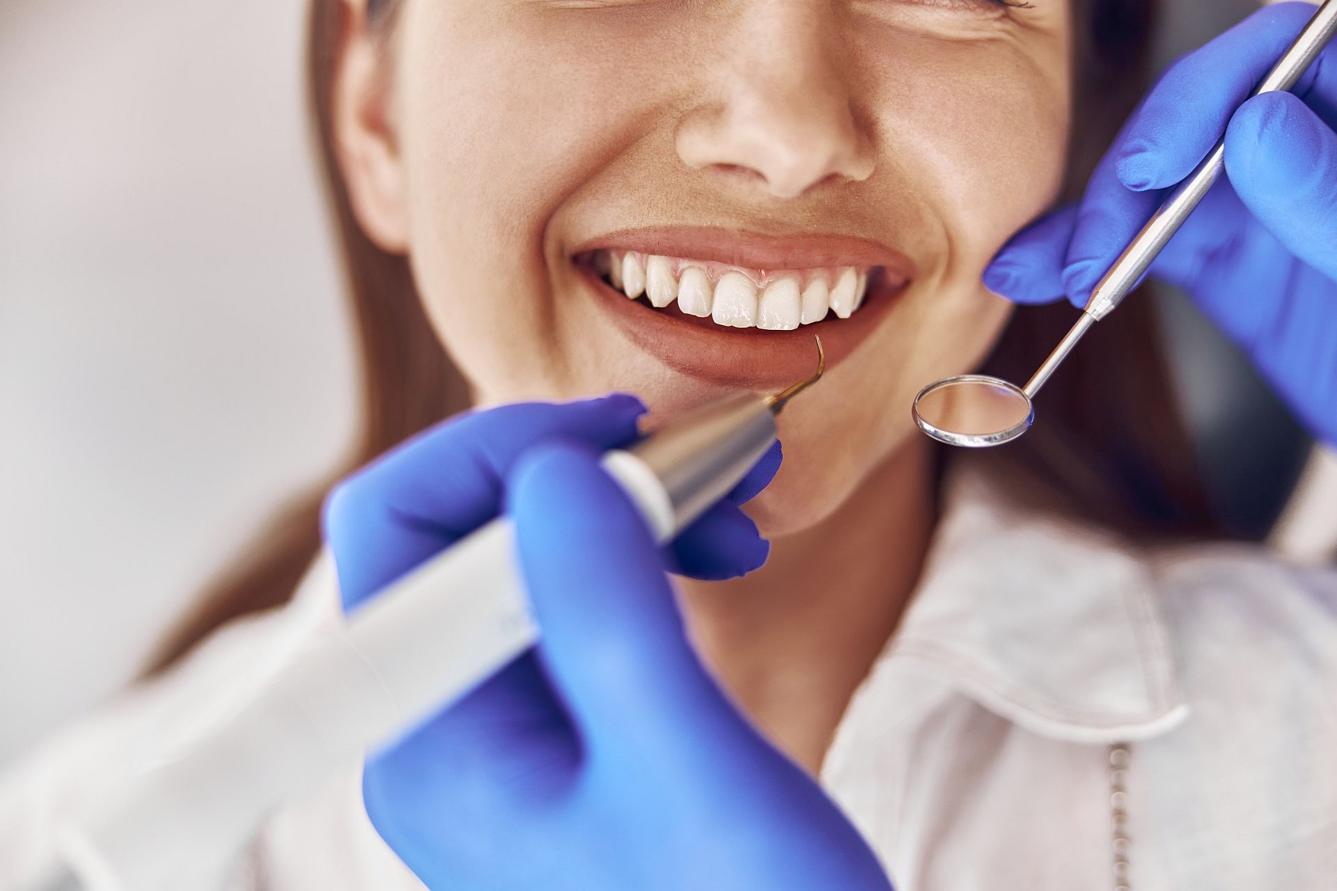 confident doctor is making ultrasonic tooth stone cleaning in modern dental cabinet confident doctor is making ultrasonic tooth stone cleaning in modern dental cabinet